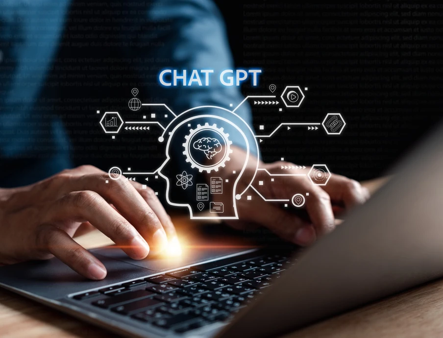 Hände tippen auf Laptop-Tastatur; holografische Grafik mit Gehirn, Linien, Hexagonen und dem Text 'CHAT GPT' leuchtet.